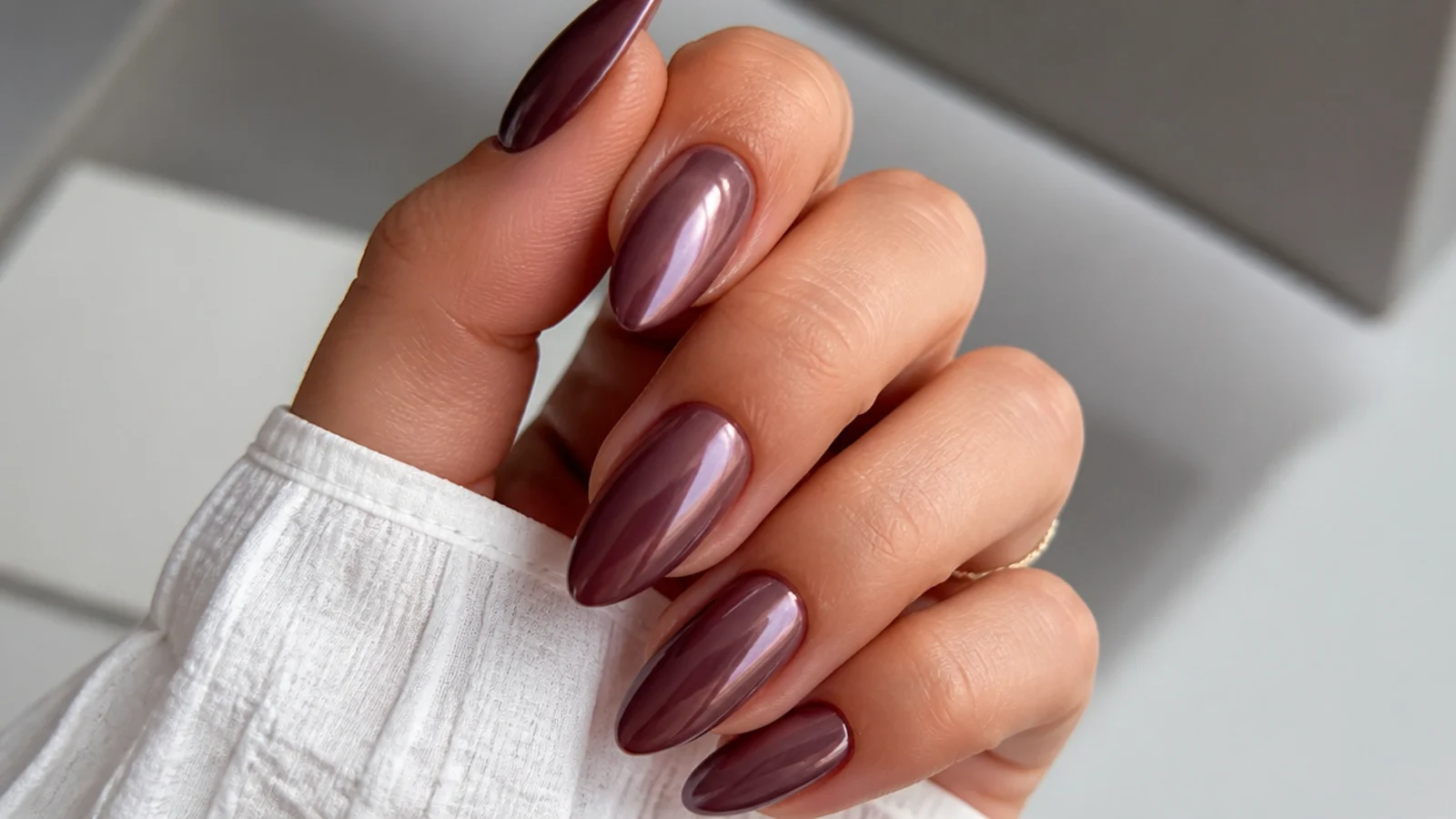 Almond nails in a moody mauve chrome with a soft metallic sheen