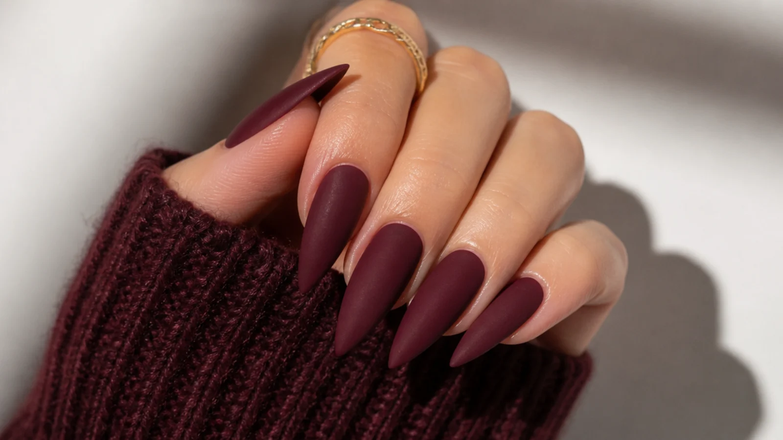 Long matte oxblood stiletto nails with a soft velvet finish