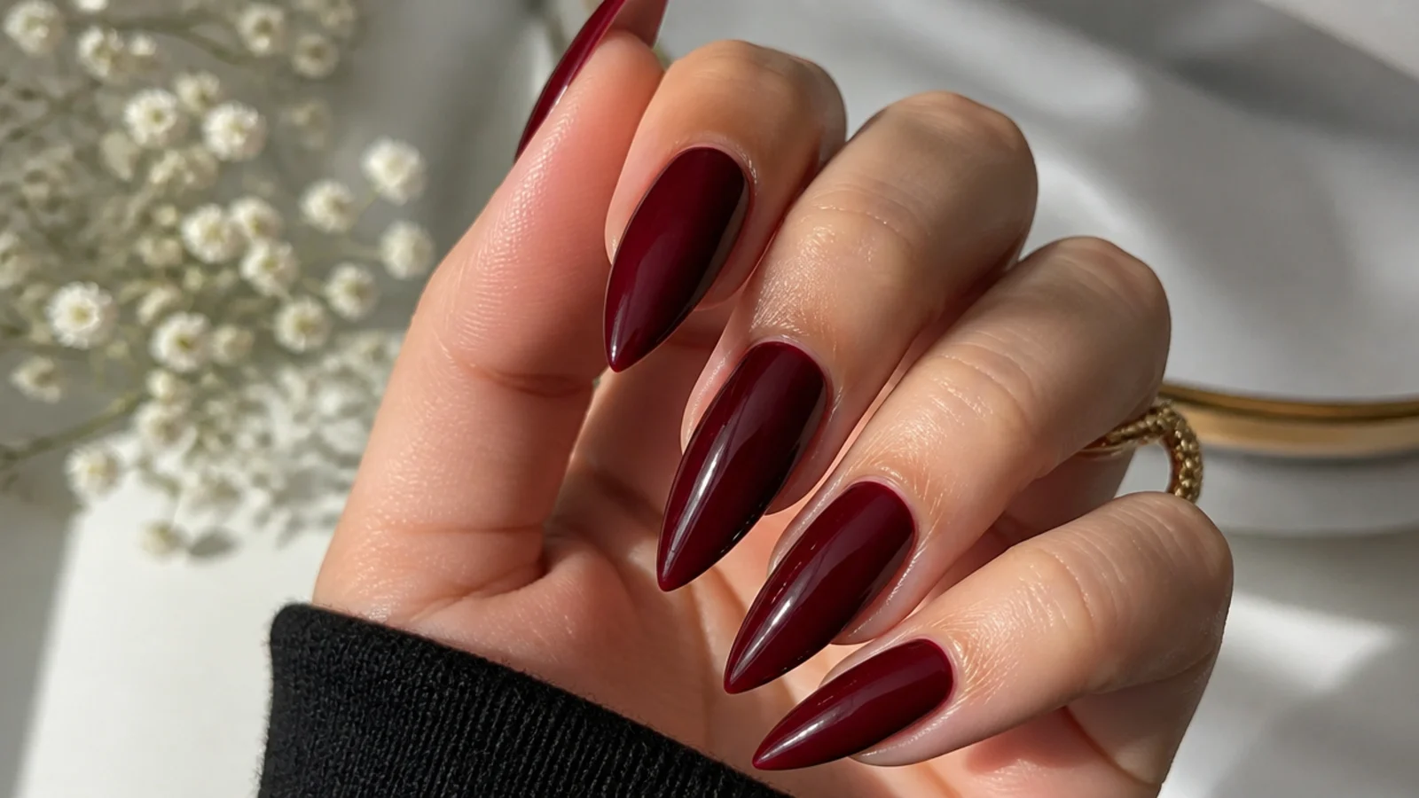Stiletto nails in deep glossy wine red with a sharp elegant point