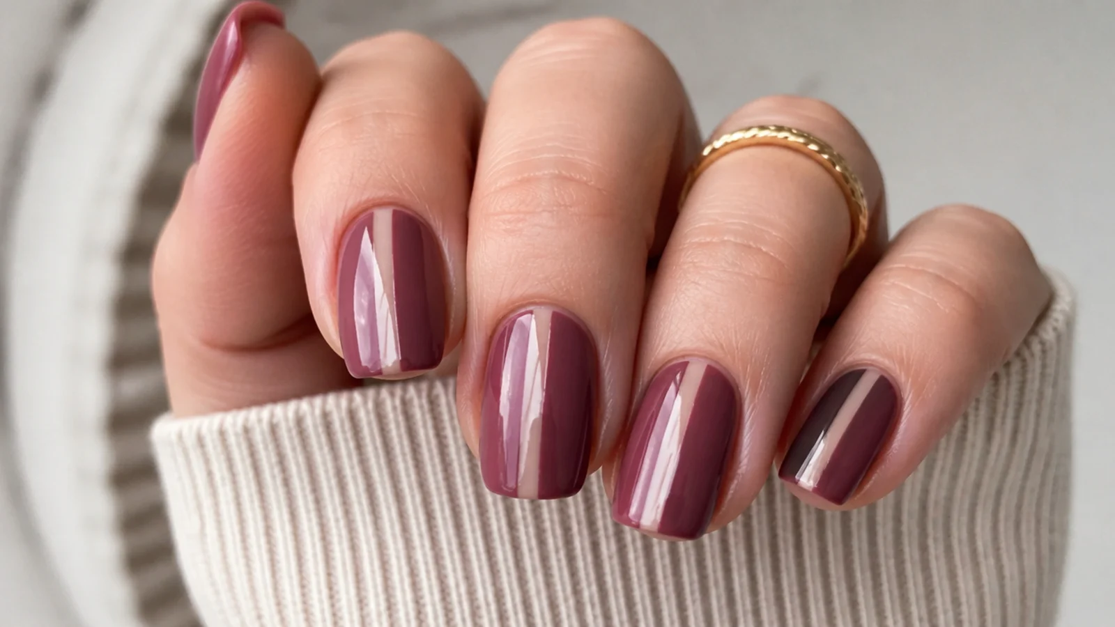 Moody mauve nails with a negative space stripe down the center