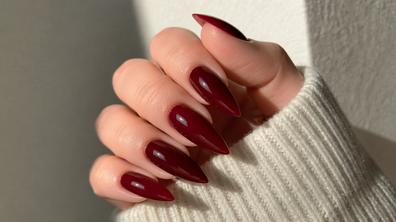 Blackened cherry red stiletto nails with a high gloss finish