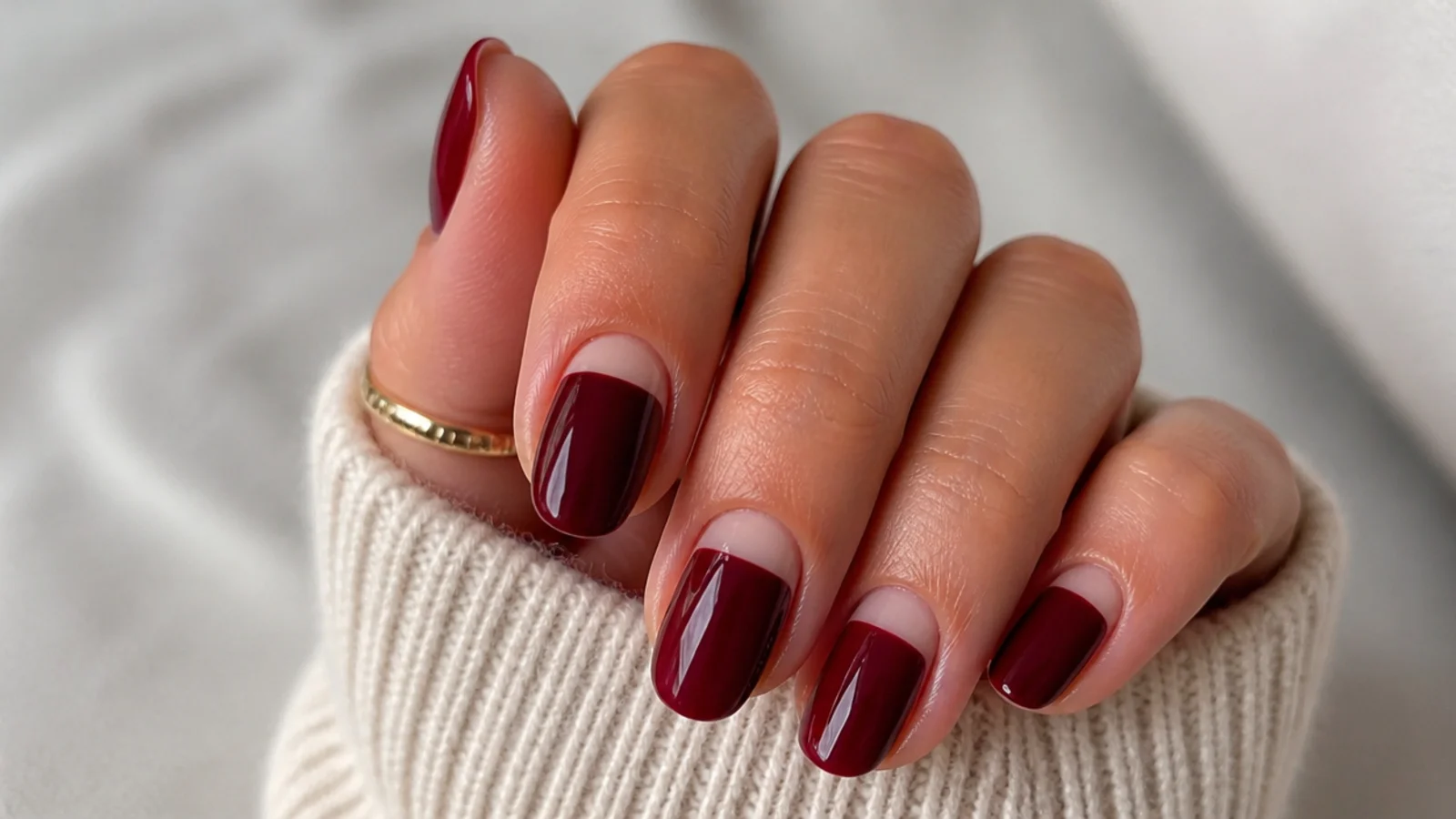 Wine red nails with a bare nude half-moon at the cuticle
