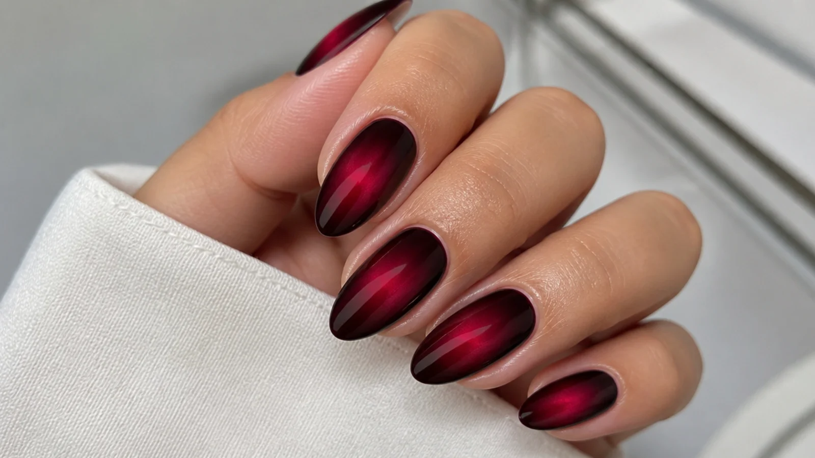 Deep merlot nails with a soft blurred aura glow at the center