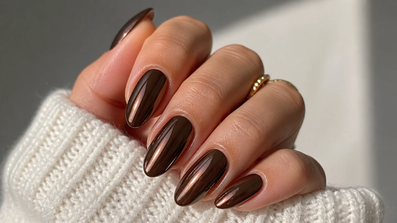 Deep chocolate brown almond nails with a mirror chrome metallic finish