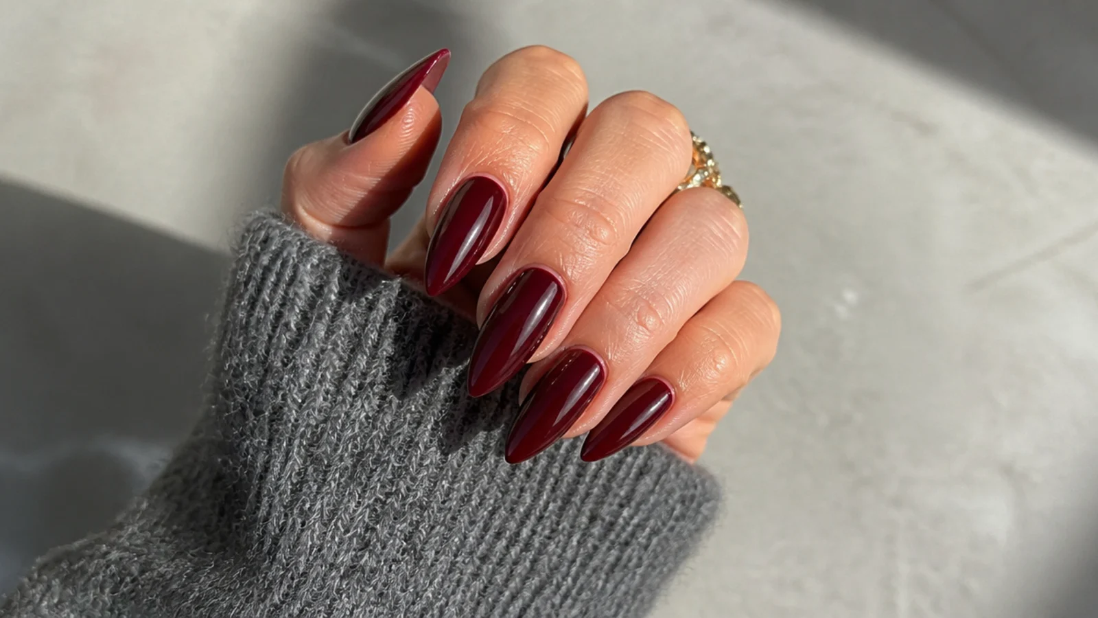 Long glossy oxblood stiletto nails with sharp tapered points