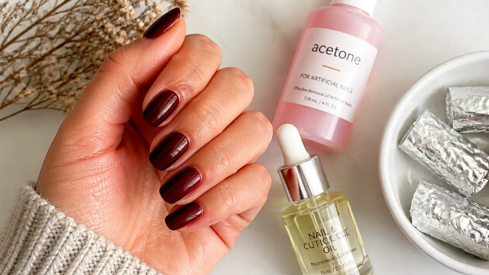 A sealed deep oxblood manicure with cuticle oil and acetone-soak removal supplies