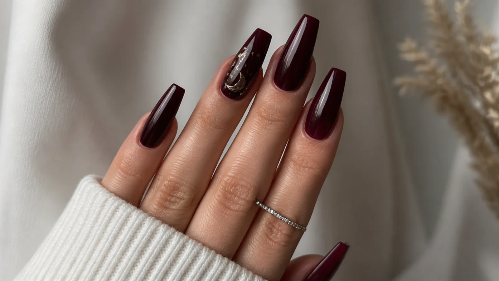 Glossy deep berry dark feminine nails on a coffin shape