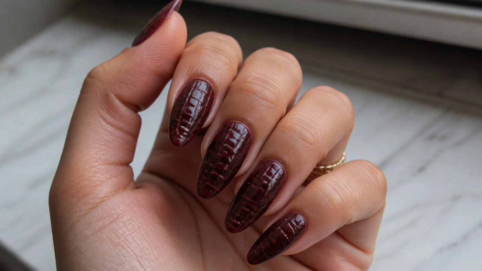 Deep burgundy 3D croc-textured dark feminine nails with subtle raised pattern