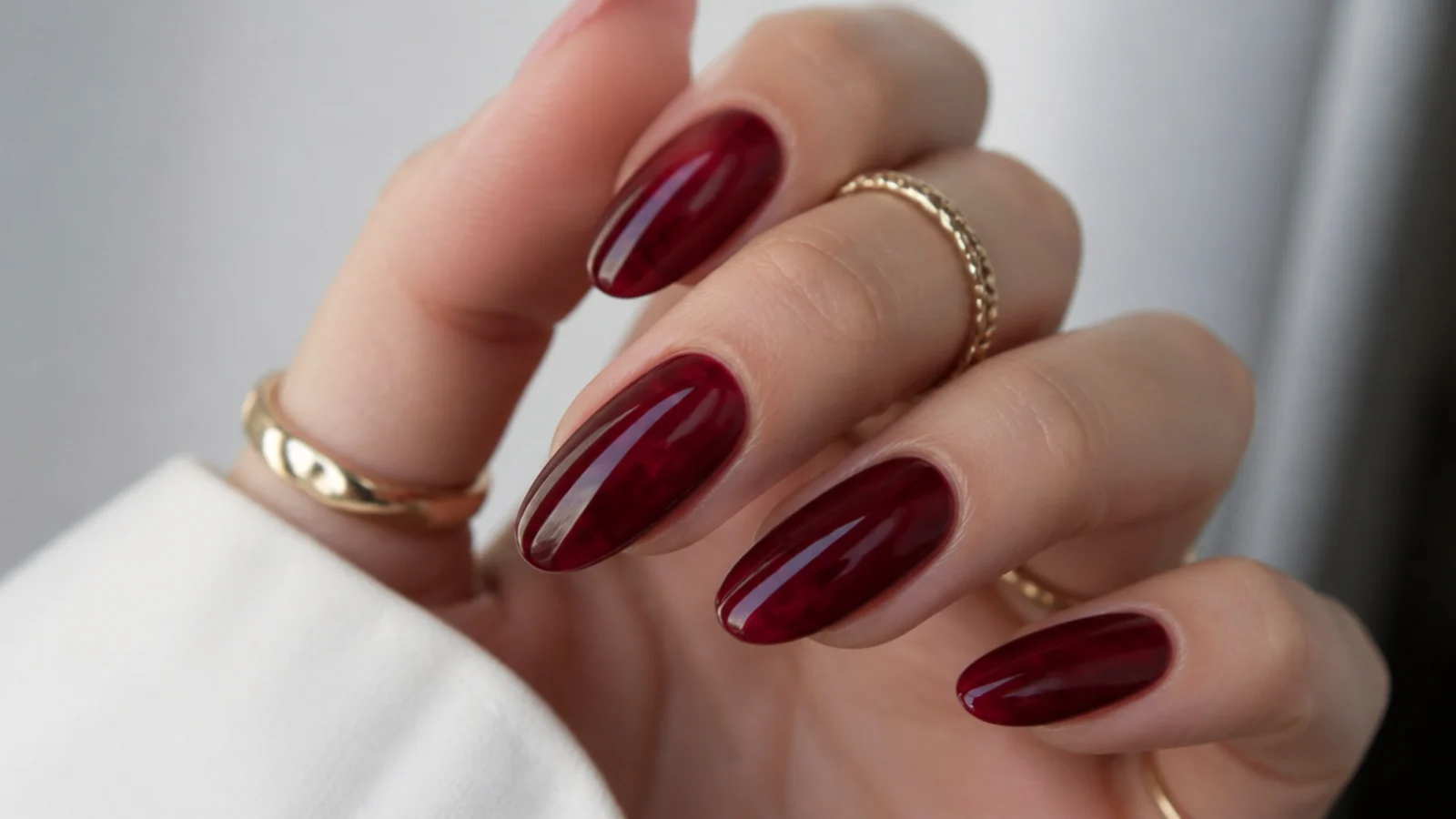 Deep garnet glass-finish dark feminine nails with a jewel-like translucent shine