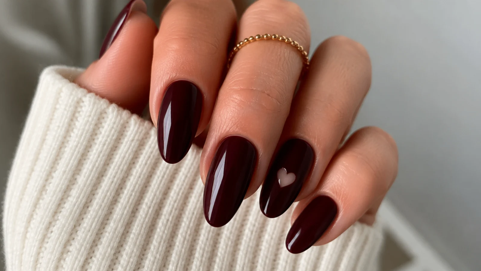 Deep berry dark feminine nails with a tiny negative-space heart cutout