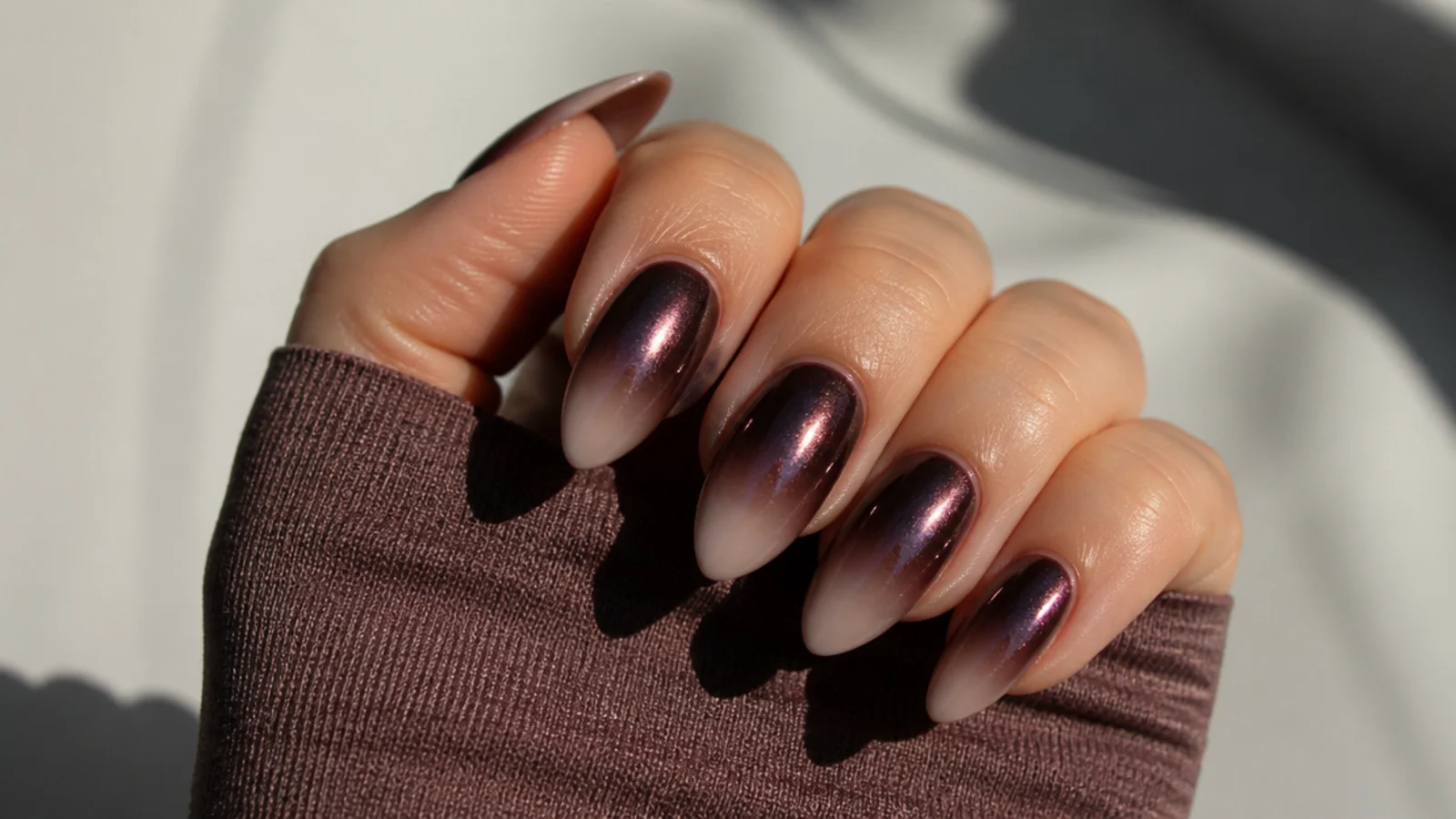 Deep mauve chrome ombre dark feminine nails fading from metallic cuticle to bare tip