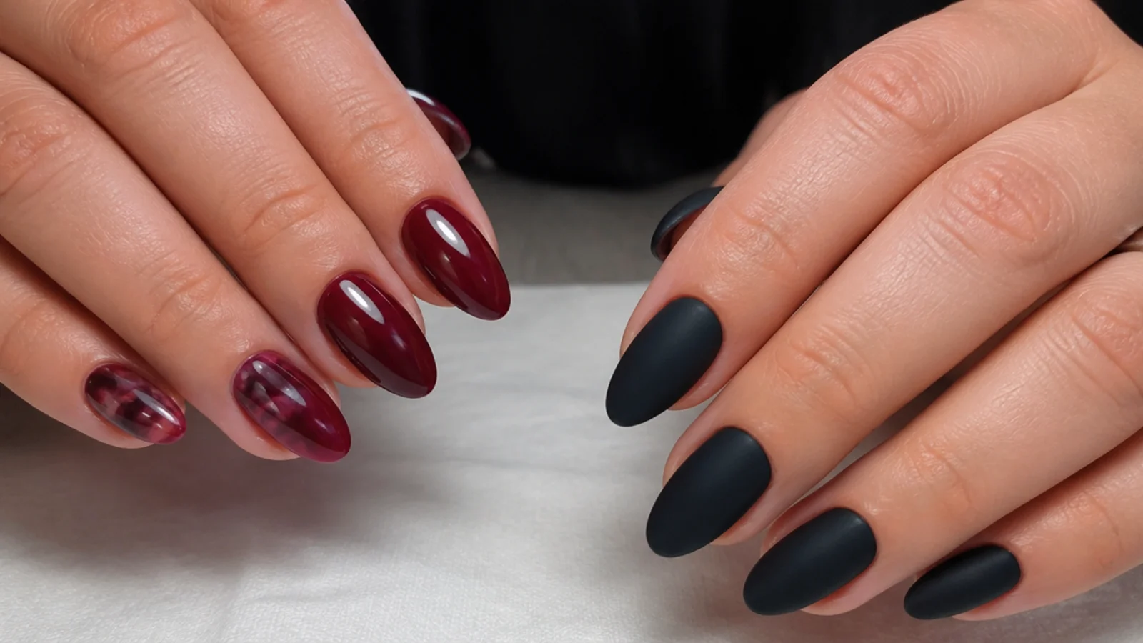 Deep warm-toned oxblood and berry dark feminine nails beside a cold flat black set
