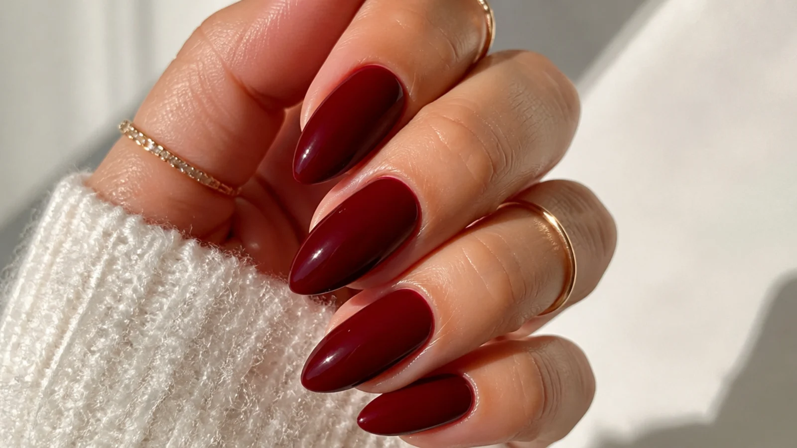 Deep oxblood red almond nails with a high-gloss finish
