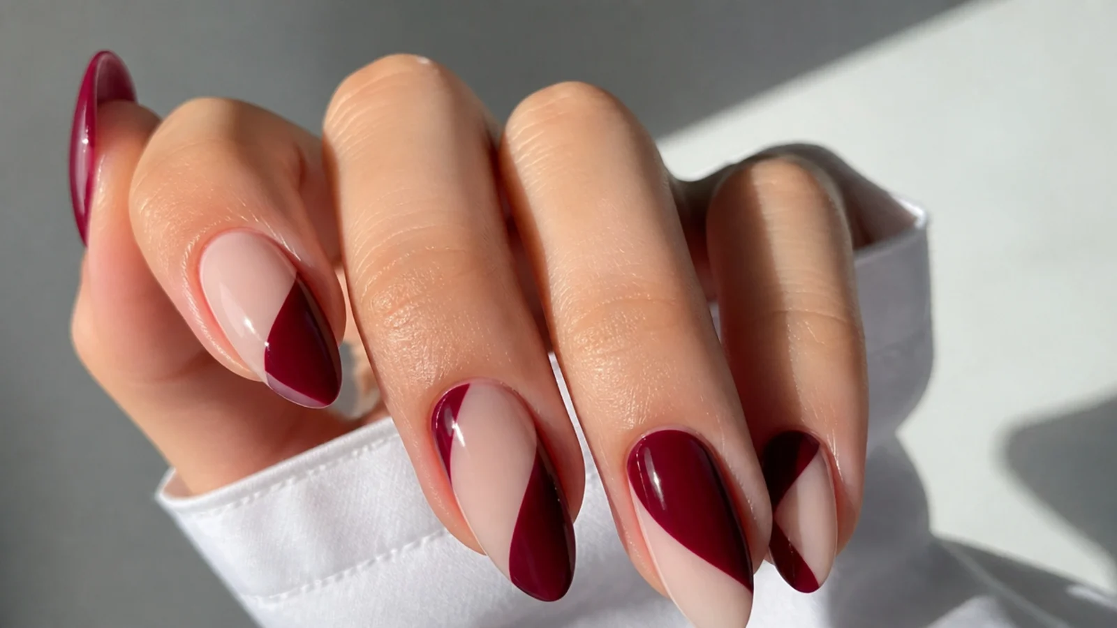 Deep berry red nails with negative space cutouts on a clear base