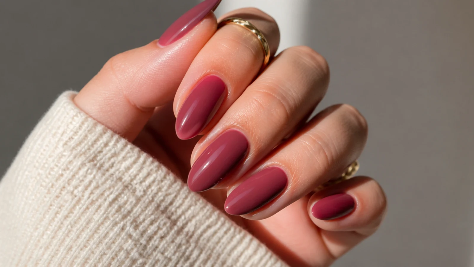 Dusty moody mauve red nails with a soft glossy finish on almond tips
