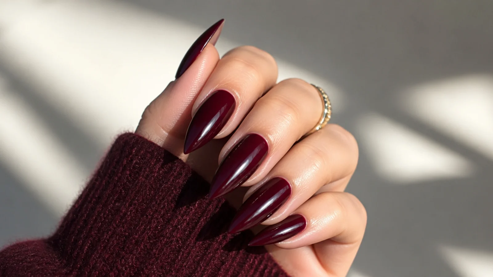 Long oxblood red stiletto nails with a high-gloss finish