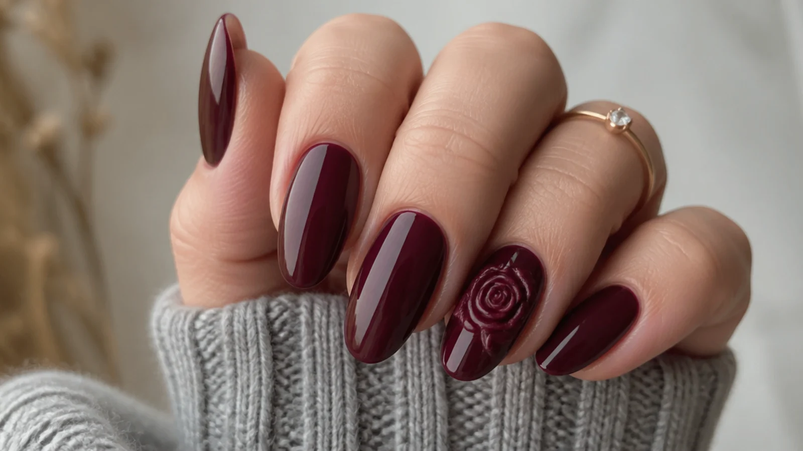 Deep wine nails with a subtle sculpted 3D rose on one accent nail