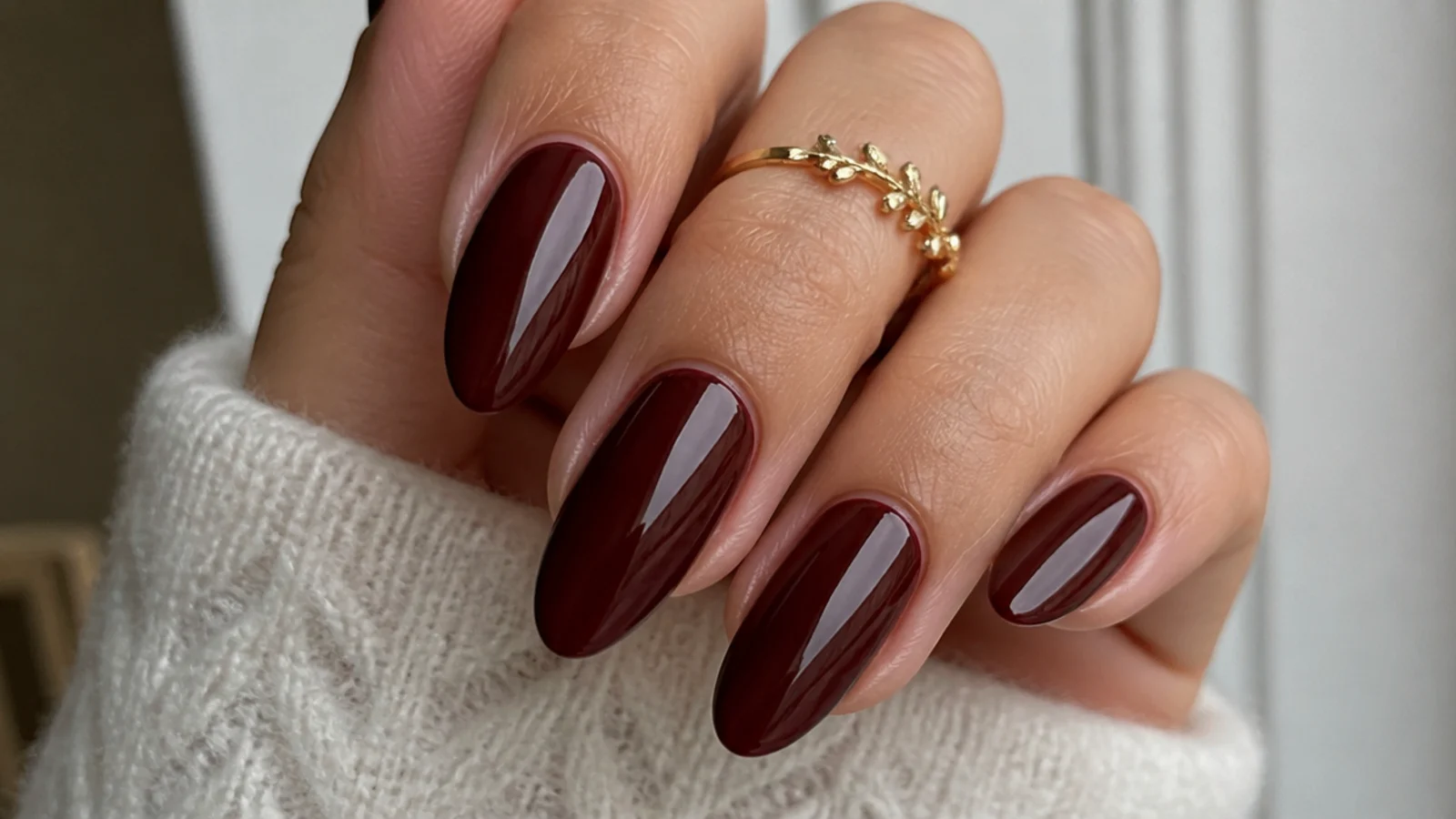 Warm mahogany red-brown nails on almond shape with a glazed shine