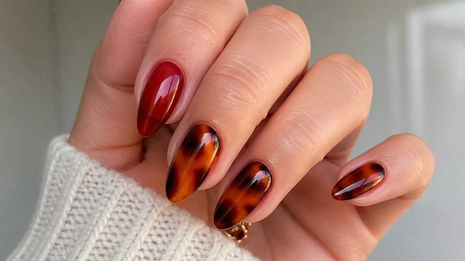 Sheer red and amber tortoiseshell nails with warm mottled tones