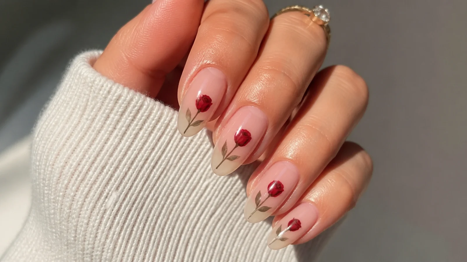 Sheer nails with a hand-painted deep red rose over negative space