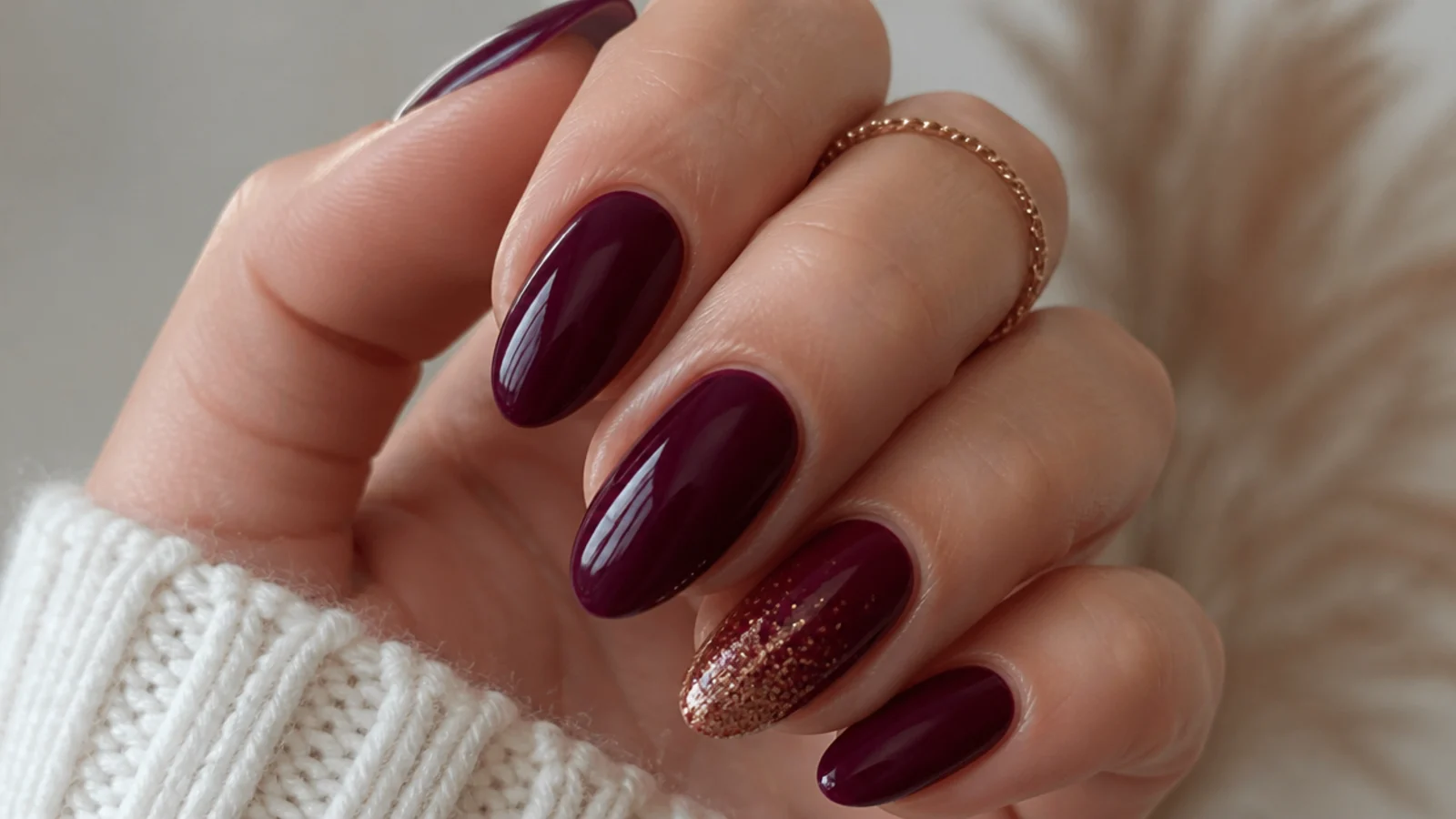 Deep wine nails with one nail fading into fine warm glitter at the tip