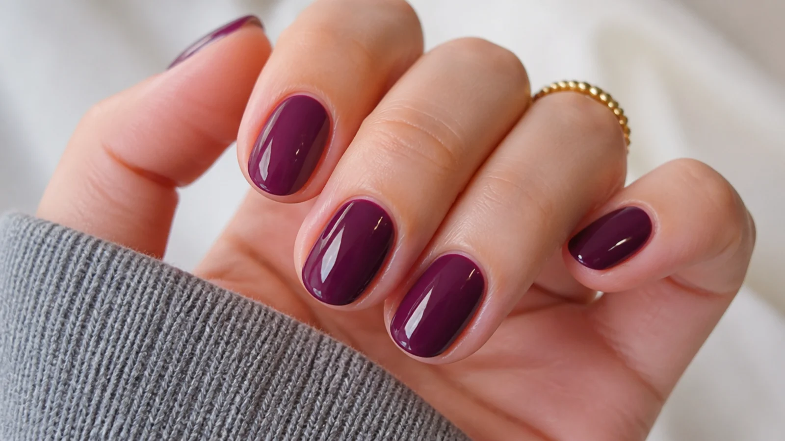 Short almond nails in glossy deep berry with a cool plum undertone