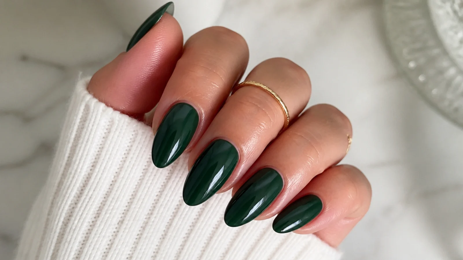 High-gloss dark emerald green nails on a medium almond shape