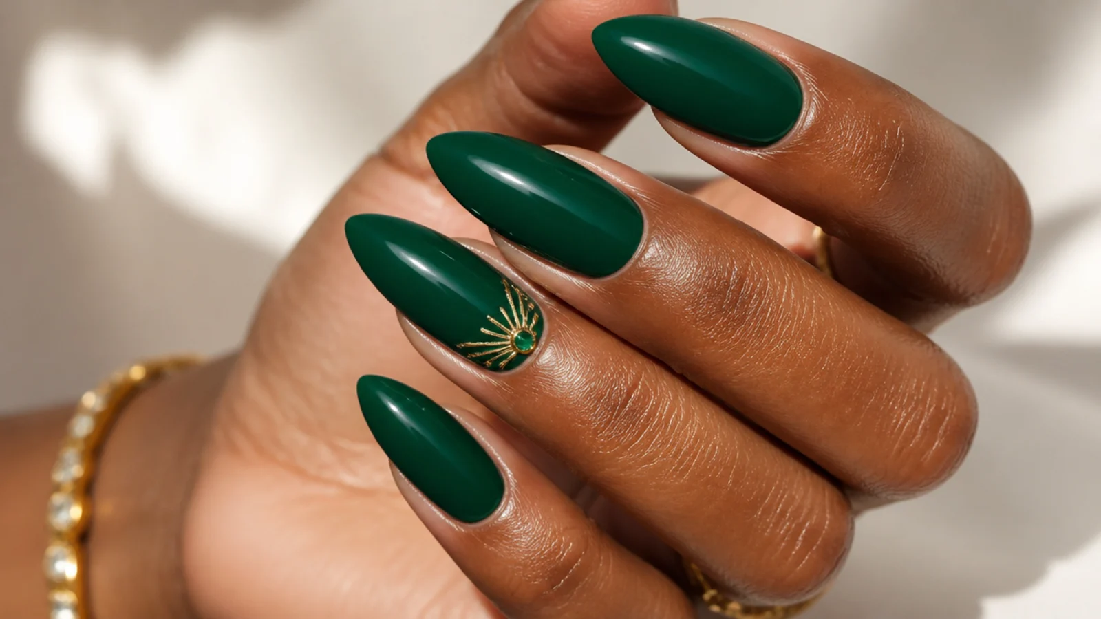 Bright jewel emerald green nails on deep skin, glossy almond shape