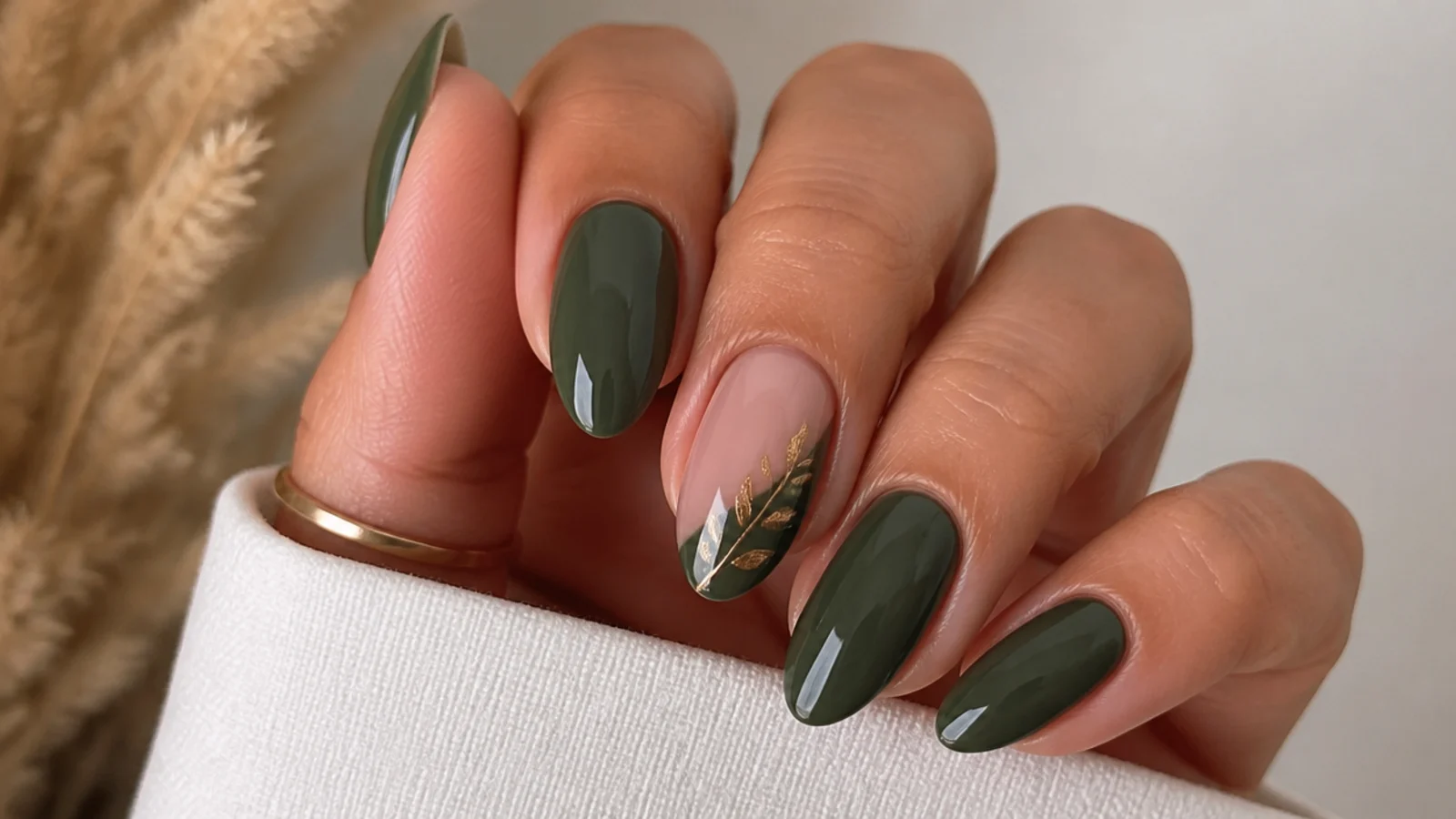 Warm olive-leaning dark green nails on tan skin, almond shape