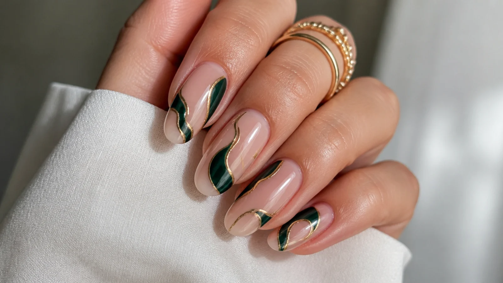 Nude nails with dark emerald and gold abstract swirl line art