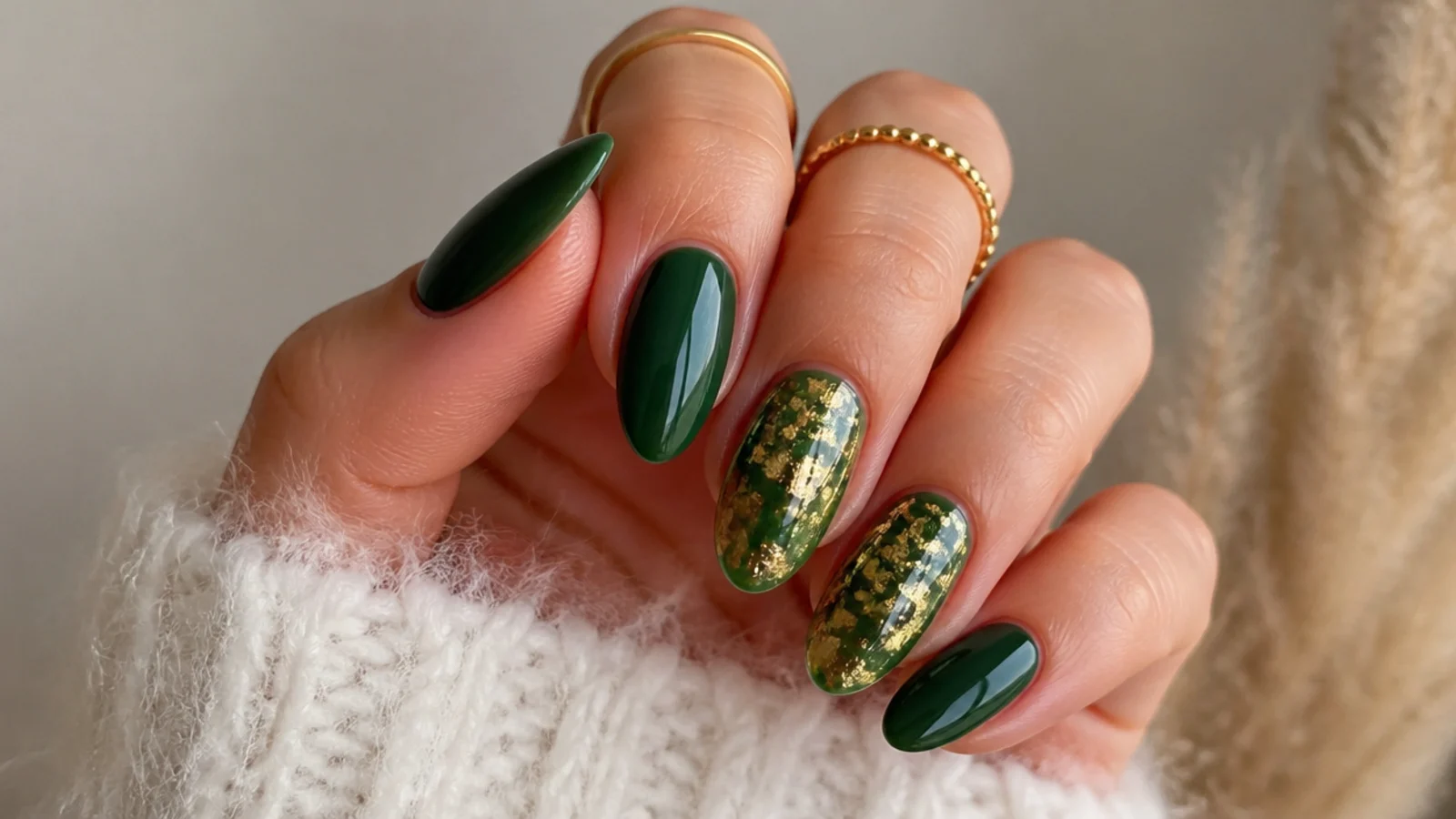 Dark green nails with gold leaf flakes on two accent nails