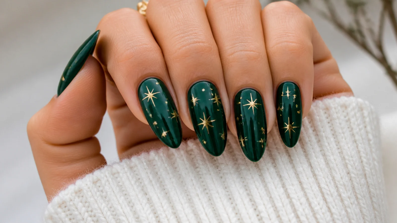 Emerald green acrylic nails with tiny gold star accents