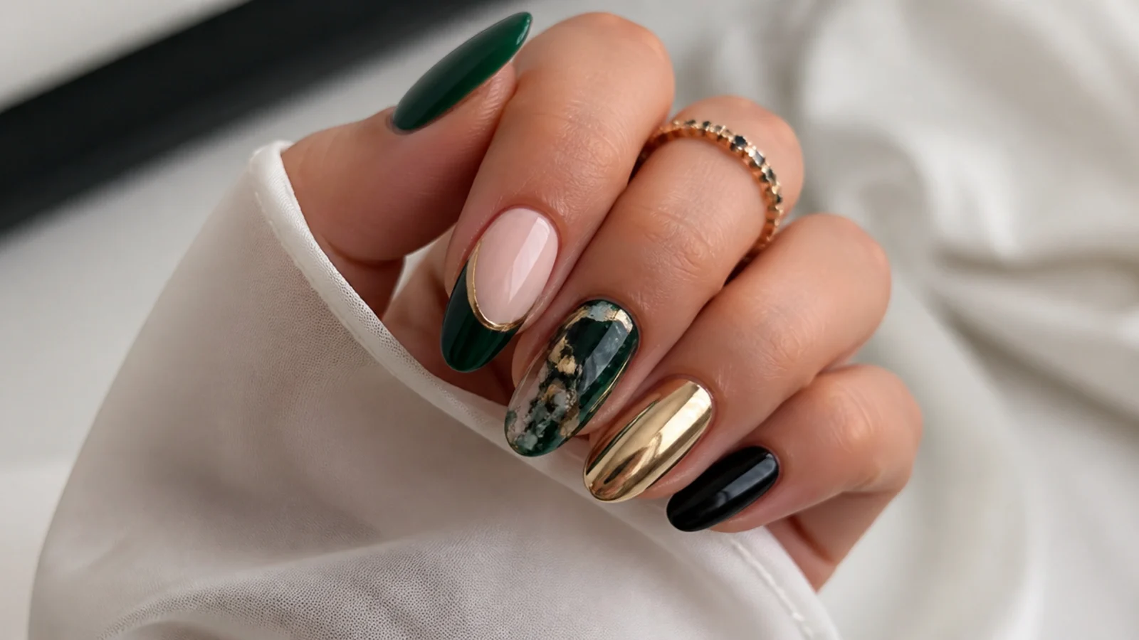 Dark green nails paired with gold, chrome, black and nude accent swatches