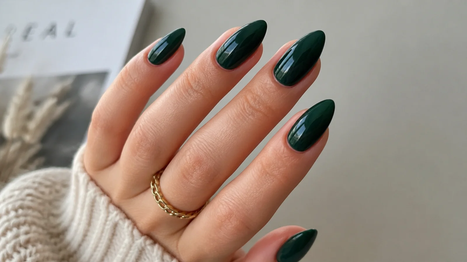 Glossy dark emerald green almond nails with a wet jewel shine