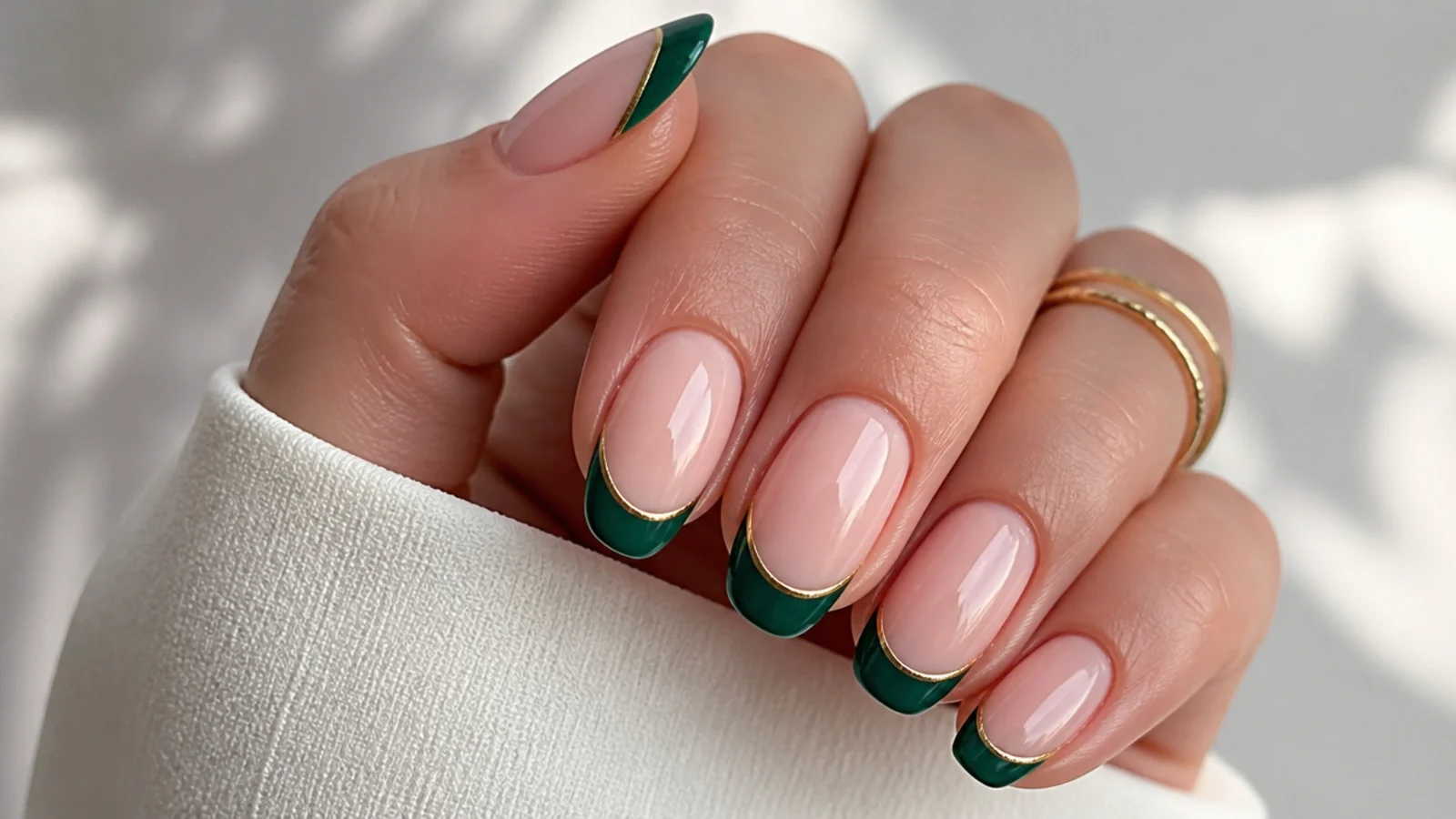 Nude nails with dark emerald french tips lined in thin gold