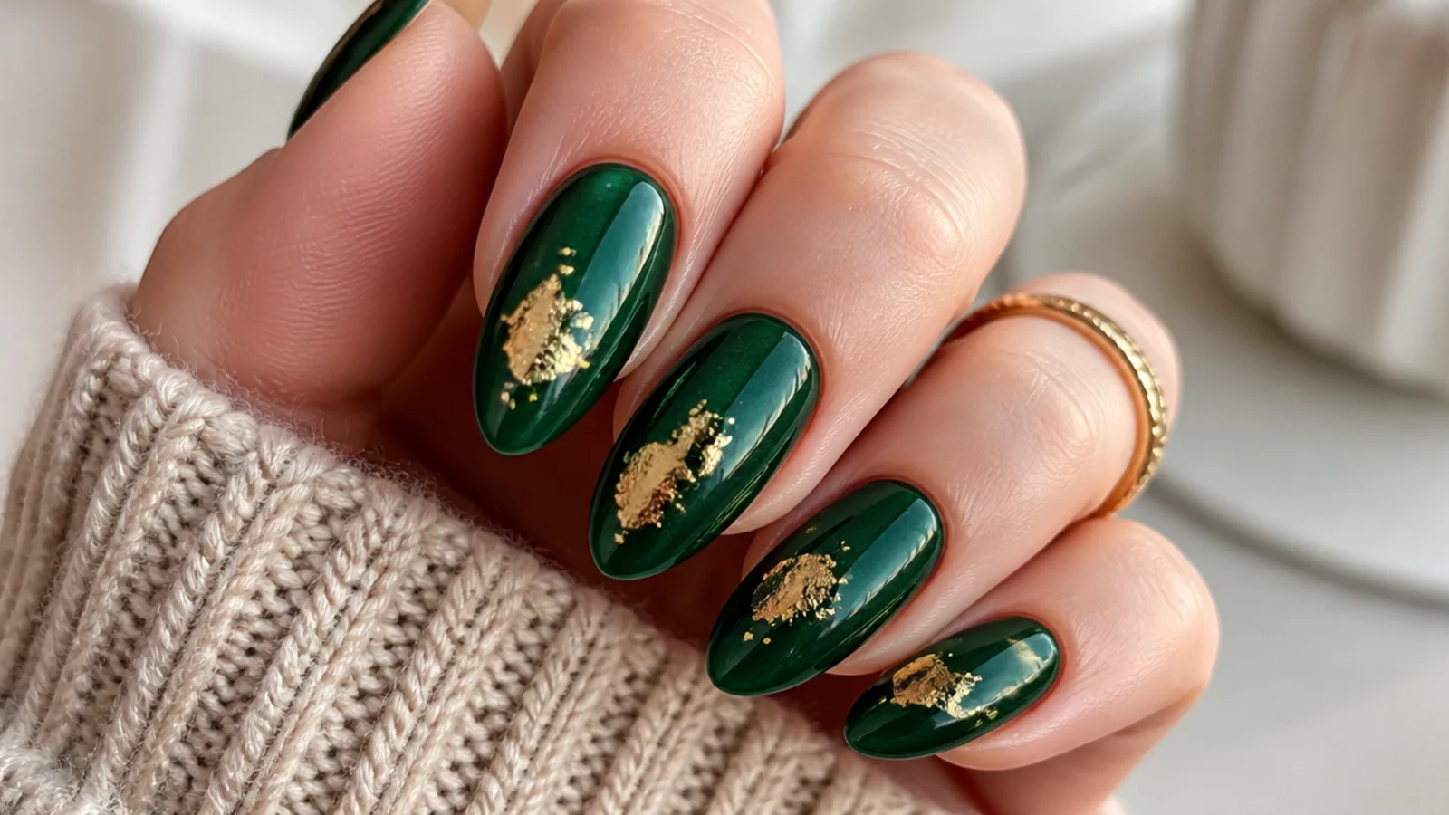 Dark emerald almond nails with torn gold foil flakes