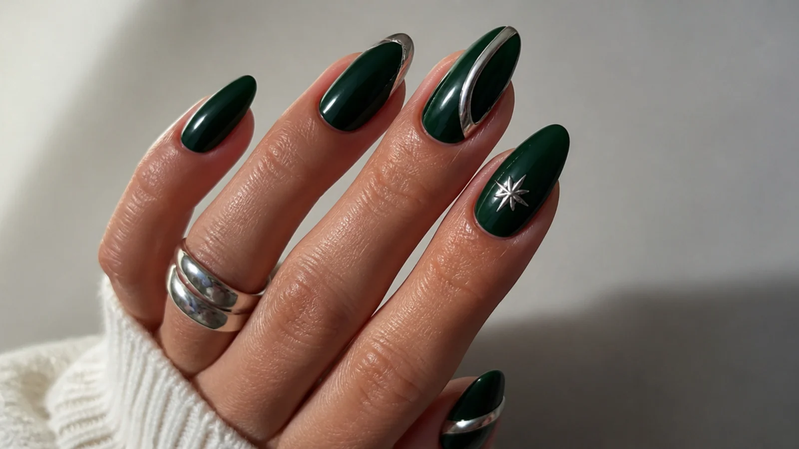 Dark emerald almond nails with silver chrome accents