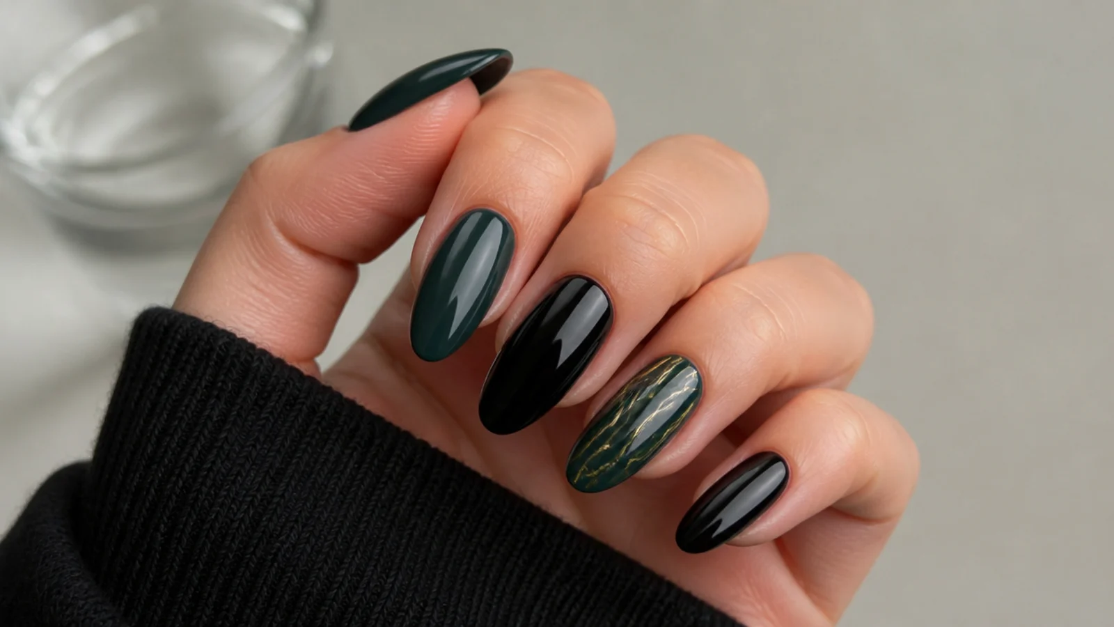 Alternating dark green and black glossy almond nails