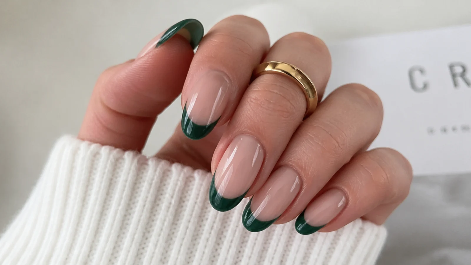 Sheer almond nails with dark emerald green french tips