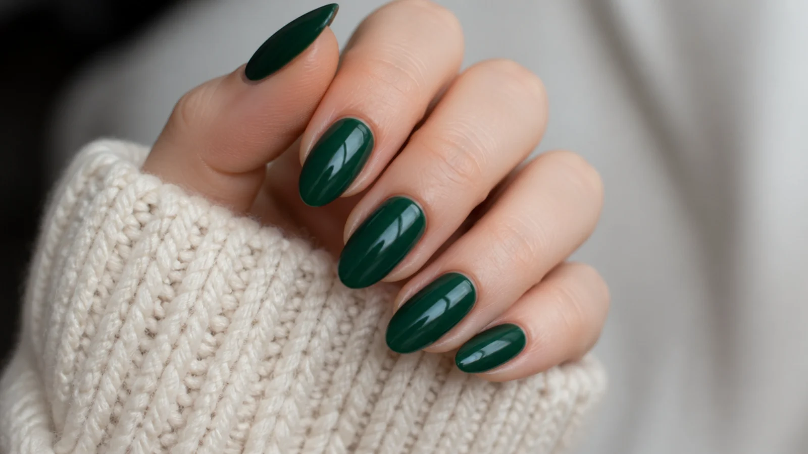 Deep hunter green glossy almond nails on fair skin