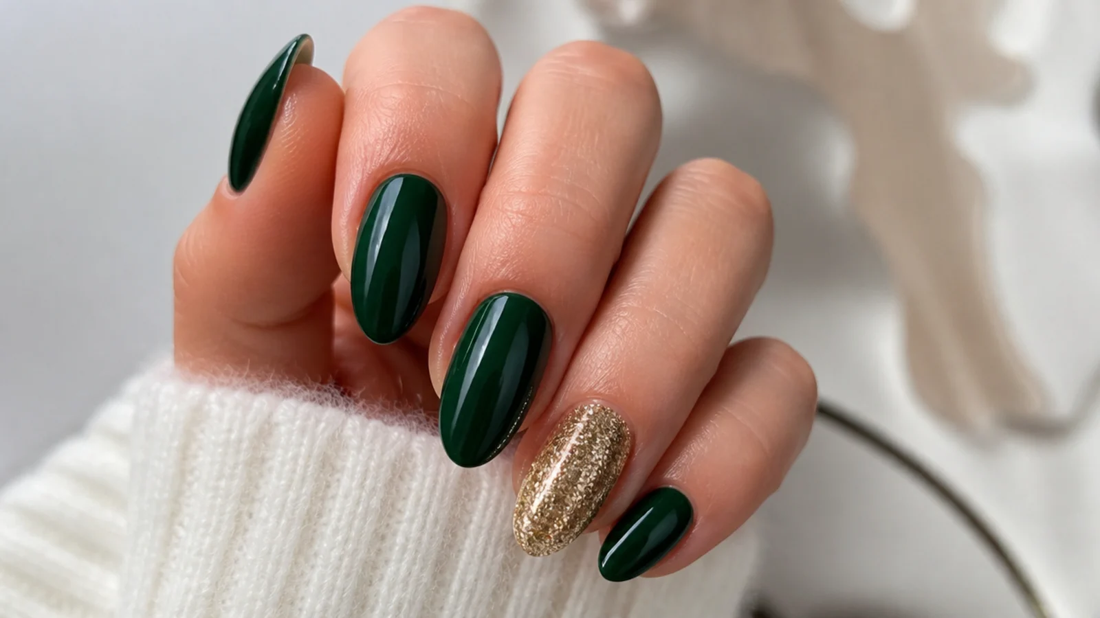 Dark green almond nails with a gold glitter accent nail