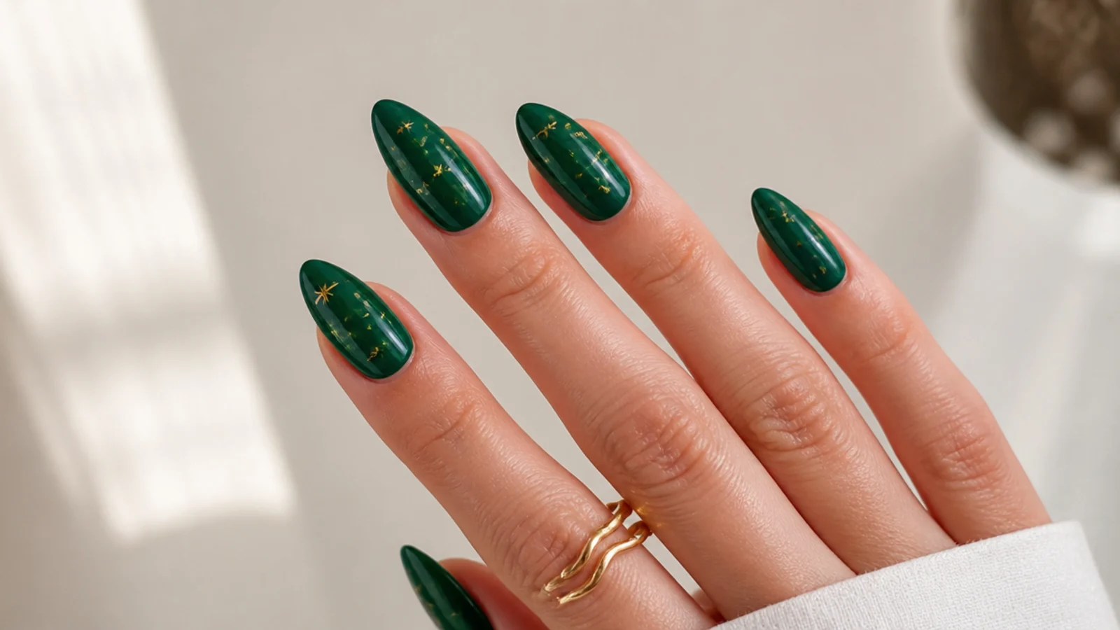 Dark emerald almond nails with small gold star decals