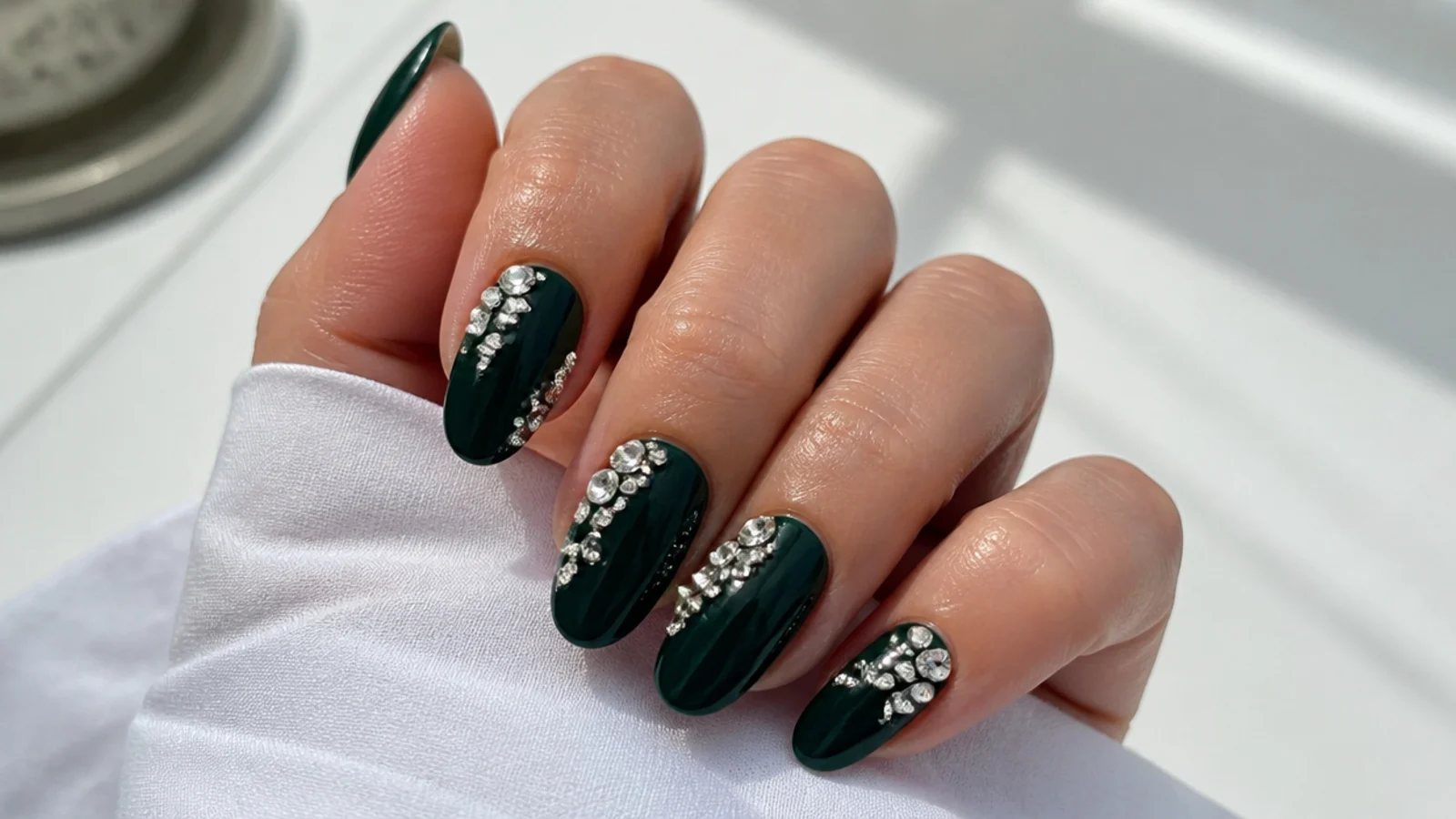 Dark emerald almond nails with clustered clear rhinestones