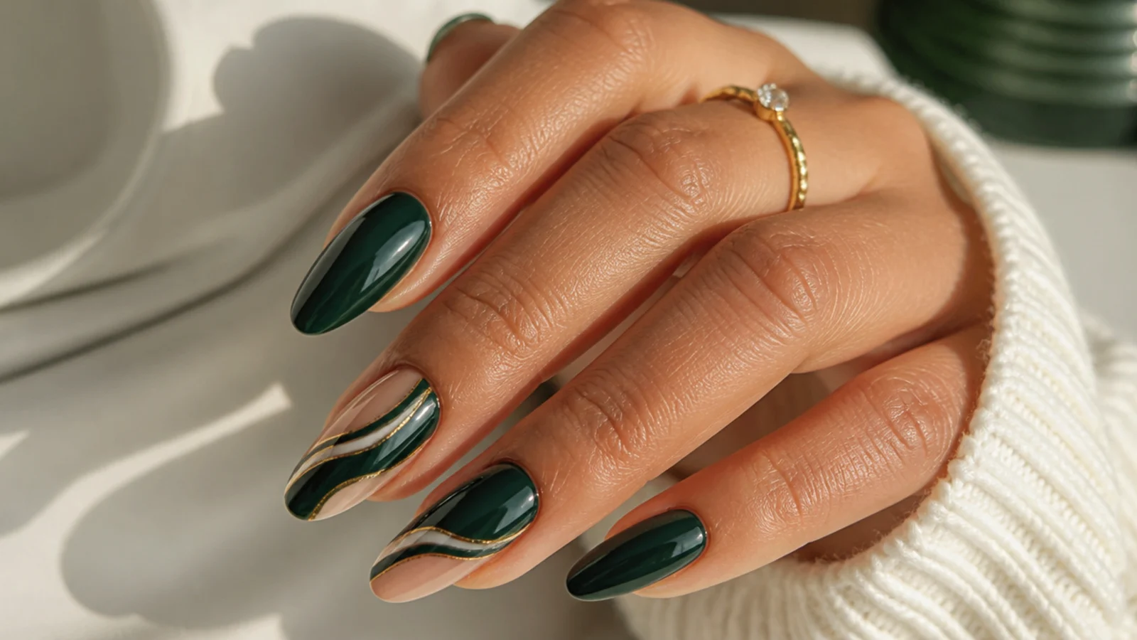 Glossy dark emerald green almond nails on a medium skin tone