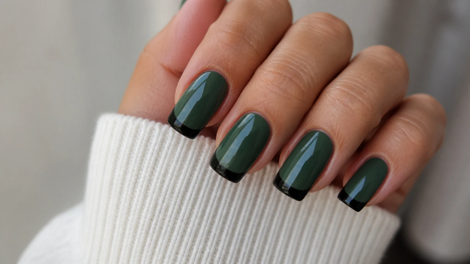 Forest green nails with sharp black french tips on a squoval shape
