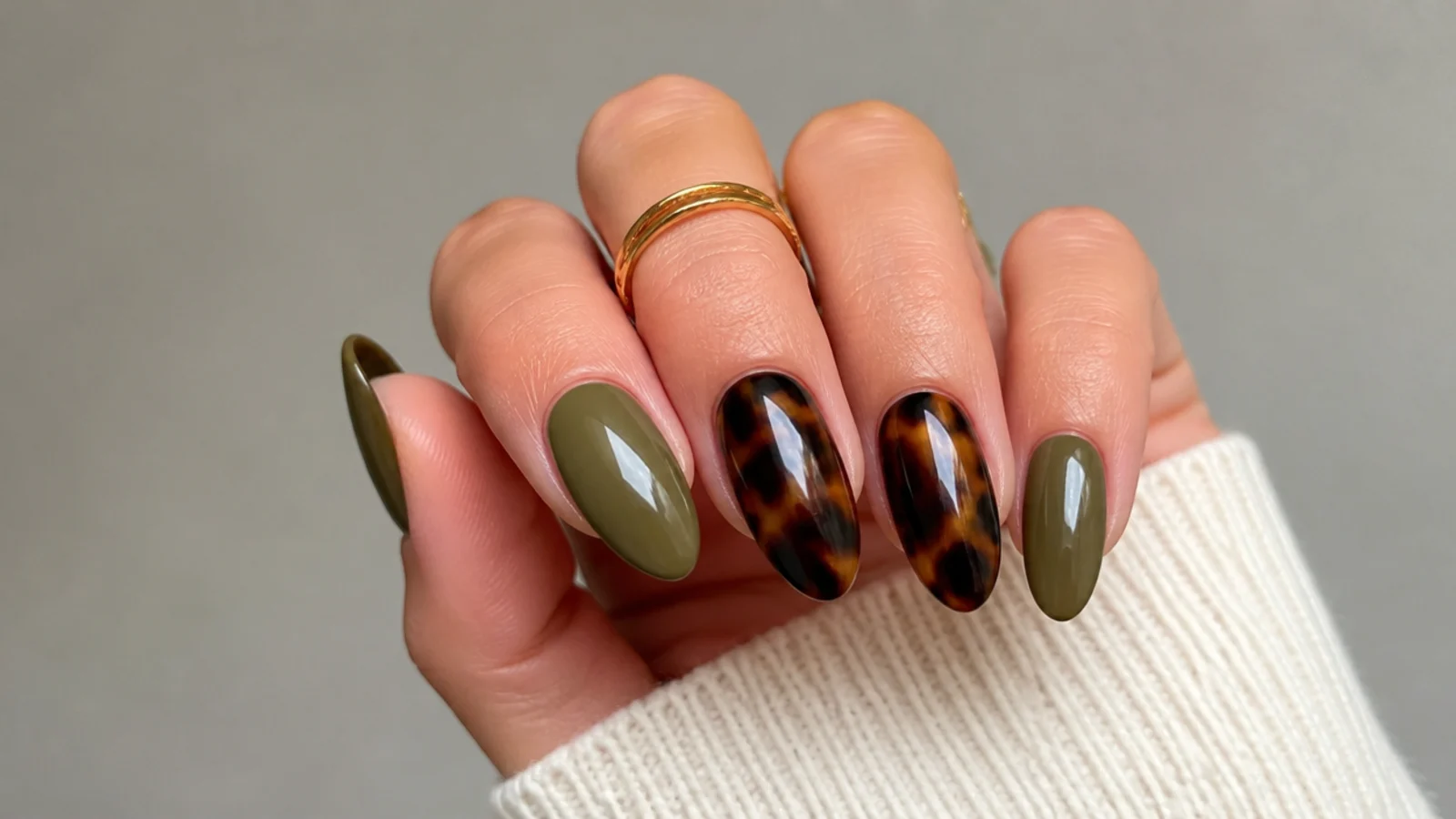 Warm olive green and black tortoiseshell nails on an almond shape