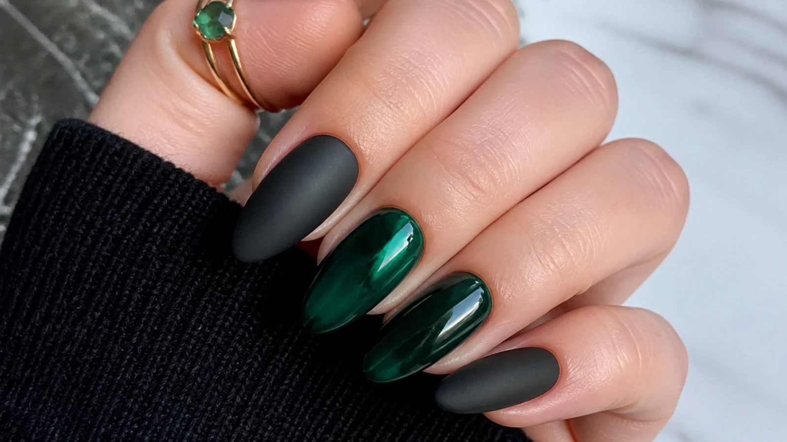 Matte black nails beside glossy emerald nails for a texture contrast