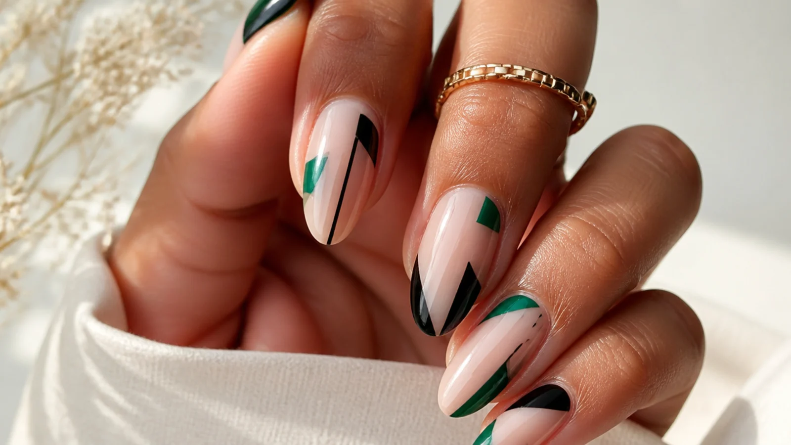 Clear negative-space nails with emerald and black geometric shapes