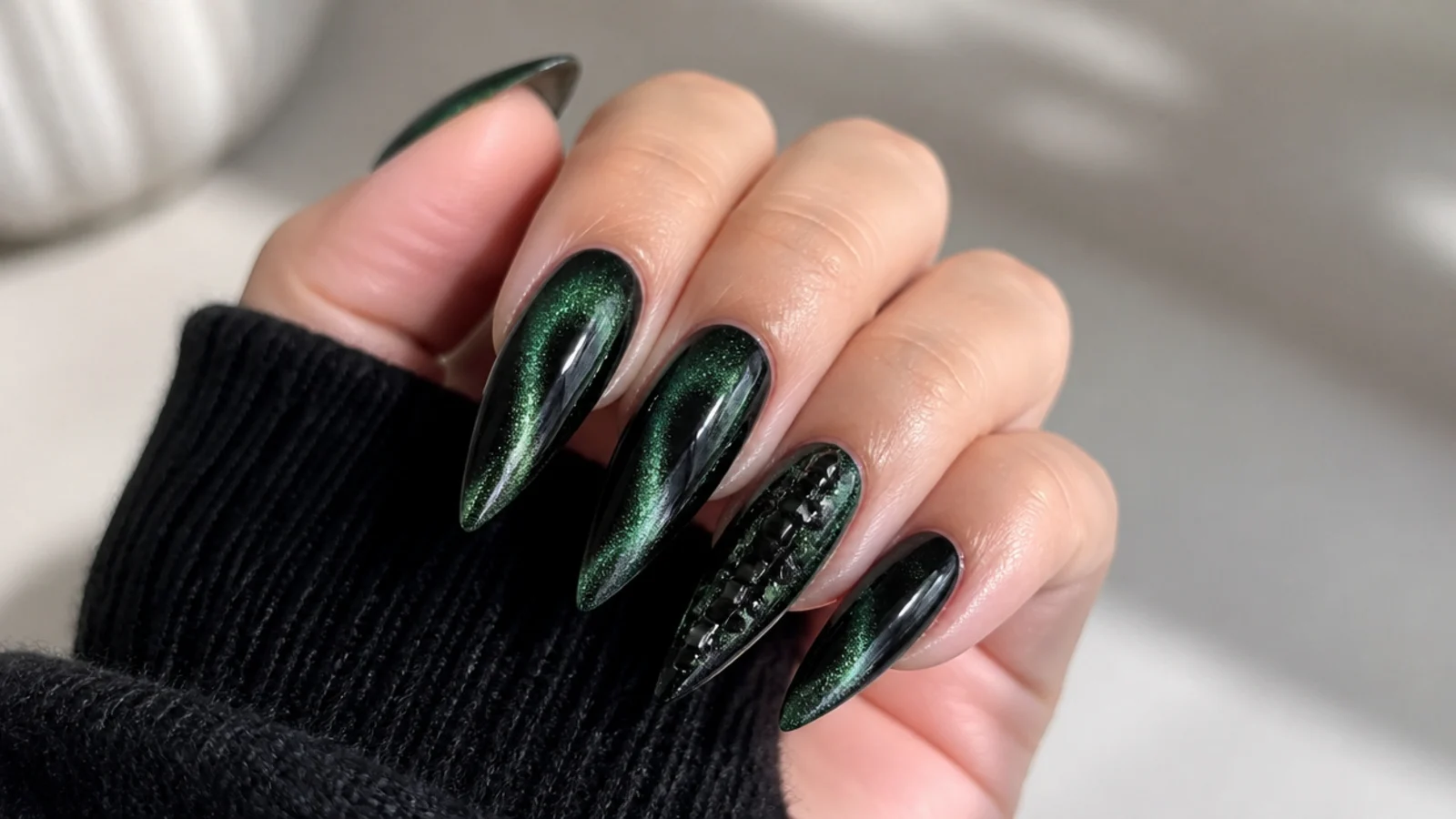 Long stiletto nails in emerald and black with a magnetic cat-eye stripe
