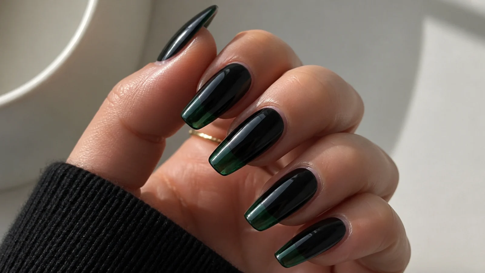 Deep glossy black nails with translucent dark green glass tips